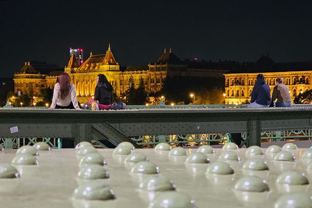 young people sitting and chatting on Liberty Bridge in the evening