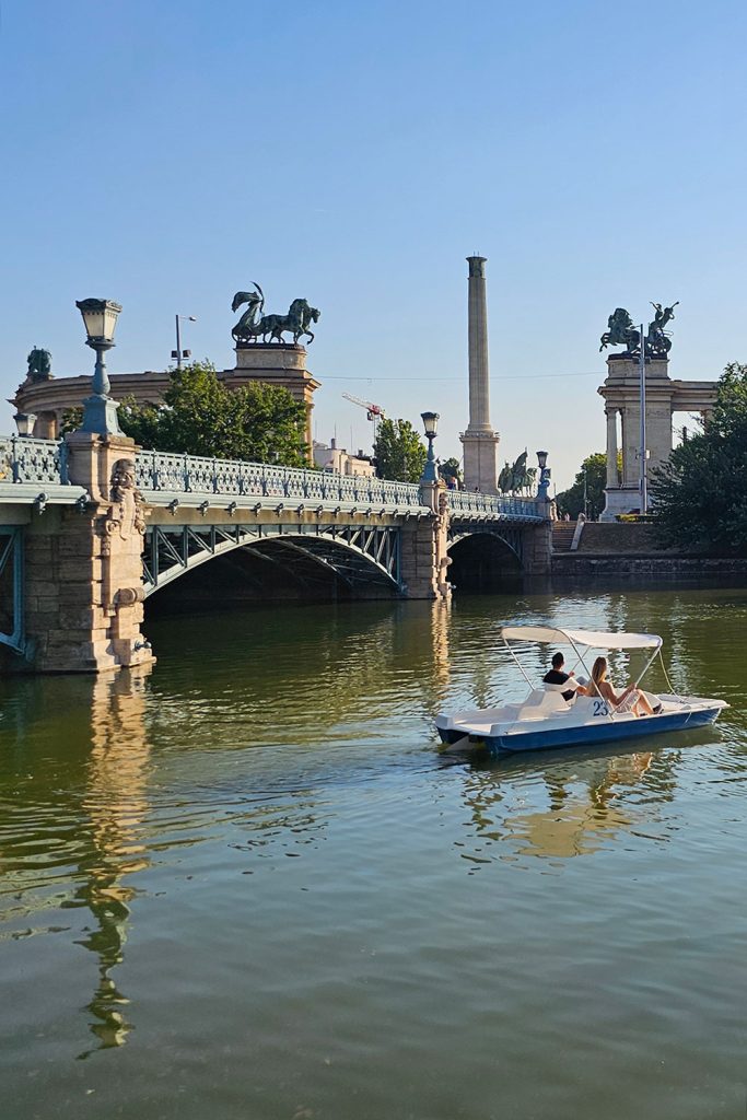 couple in a boat at City Park Lake in Budapest in front of Heroes Square