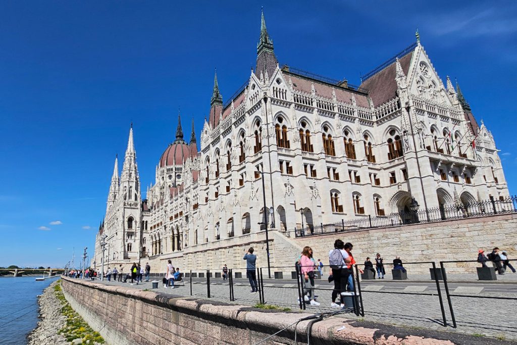 people dressed in casual clothes walking in front the Parliament