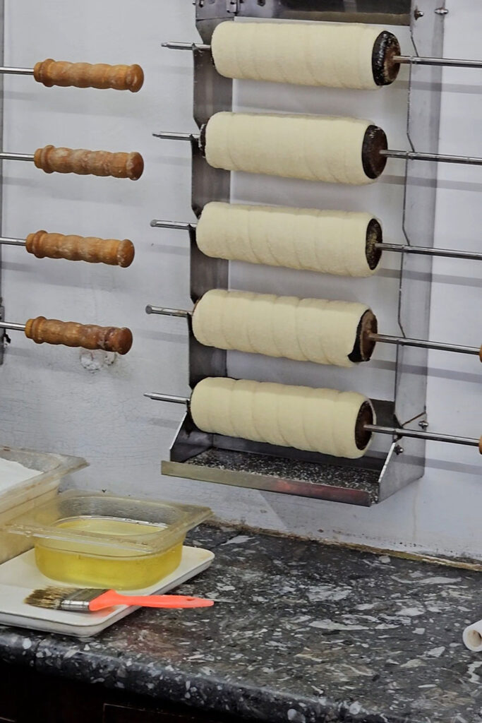 Chimney cakes on wooden rools prepared for baking
