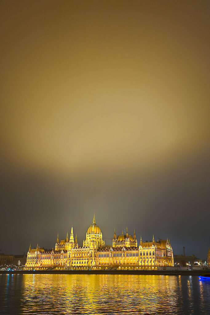 golden light reflecting on the sky above the Hungarian Parliament on a cold winter day